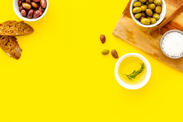 Obraz na płótnie Canvas Mediterranean olives near bread on cutting board top view copy space