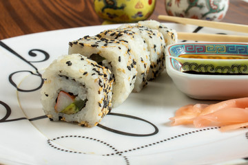 sushi rolls on a plate whith soy sauce