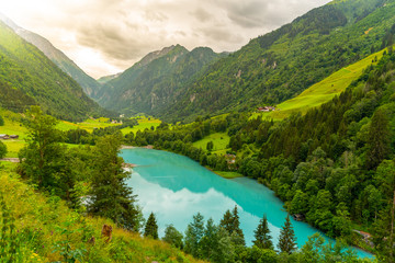 Fototapeta na wymiar Klamsee - mountain water reservoir above Kaprun town with bright turquoise blue water, Austria