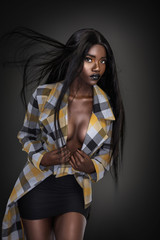 A portrait of a serene young black female with long black hair, beautiful makeup, popping dark lip...