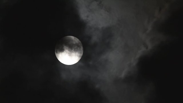 Lua com passagens de nuvens escuras 
