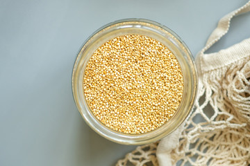 Close-up millet flat lay. Organic bio products in zero waste shop. Foods storage kitchen low waste lifestyle. Cereals and grains in glass jars. Eco friendly shopping plastic free grocery store.