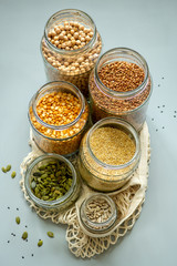 Organic bio bulk products in zero waste shop. Foods storage in kitchen at low waste lifestyle. Cereals and grains in glass jars on table. Eco friendly shopping in plastic free grocery store.