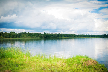 lake in summer. The pond with the forest in the summer. View of the lake with sky, clouds and forest.
