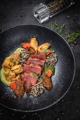 Grilled tuna fish. In a dark plate on a dark concrete table
