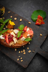 hearty breakfast - sweet bruschetta with cheese, strawberries, jam and mint.
