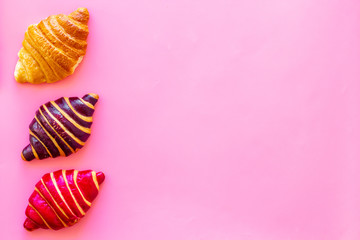 Set of croissants - chocolate, berry, classic - on pink background top view