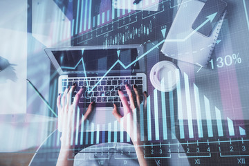 Double exposure of woman hands working on computer and forex chart hologram drawing. Top View. Financial analysis concept.