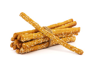 Grissini breadsticks with sesame seeds tied with string, isolated on a white