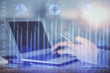 Double exposure of man's hands holding and using a digital device and forex graph drawing. Financial market concept.