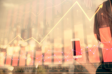 Double exposure of forex chart sketch hologram and woman holding and using a mobile device. Stock market concept.