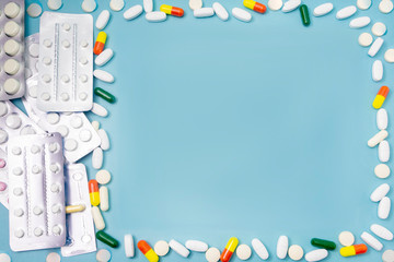 Mockup for medical theme and pharmacy. Various pills and capsules of medicines are scattered on blue background, copy space