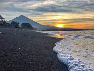 amed bali black sand beach with volcano