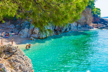 HVAR, CROATIA, AUGUST 8 2019: Tourists swimming in the beautiful and crystal water of Jagodna Beach in Hvar Island, Adriatic Sea - obrazy, fototapety, plakaty