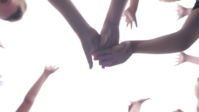 Kids team building. A group of happy children holding hands together. Team outdoor in park