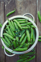 fresh green peas on wooden surface