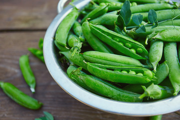 fresh green peas on wooden surface