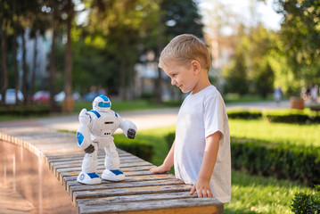 little boy playing outside with a robot