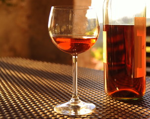Weinglas und Flasche auf einem Tisch im warmen Licht der Toskana