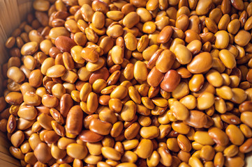 Exotic colorful mexican beans on wicker basket. Top view of legumes. Concept of beans food. Exotic beans on wooden table. Rustic background of beans. Colorful legumes on rustic setting.