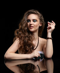 Beauty portrait of young woman sit at the black table. Snapping fingers.