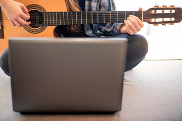 Woman learning online how to play guitar