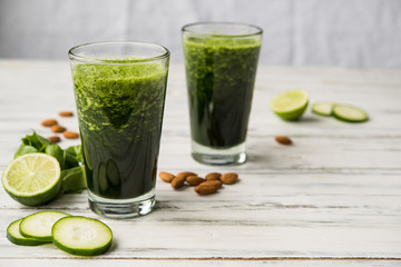 Spinach and almond smoothies against white wooden background. Concept of healthy food, eating, and lifestyle.