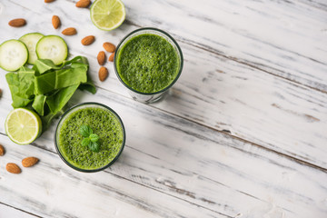 Spinach and almond smoothies against white wooden background. Concept of healthy food, eating, and lifestyle.