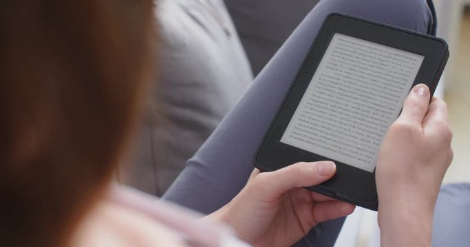 A woman reading an e-book at home.
