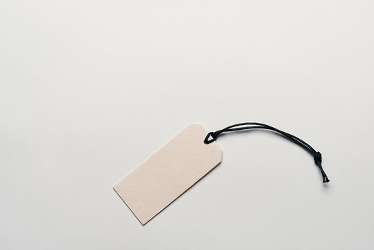 The price tag made of cardboard is empty without inscriptions on a light background.