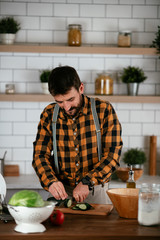 Fototapeta na wymiar Portrait of handsome man in kitchen. Young man preparing delicious food.