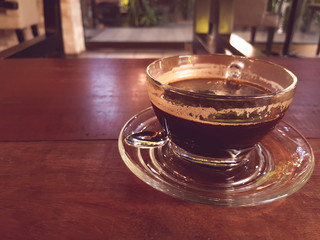 Hot black coffee on wooden tablet at coffee shop