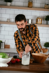 Fototapeta na wymiar Portrait of handsome man in kitchen. Young man preparing delicious food.
