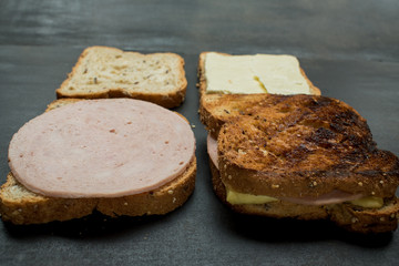 Fresh sandwich with jam and cheese on a dark wooden table 