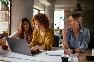 Businesswomen working on a new project. Colleagues discussing about problem they have to solved.