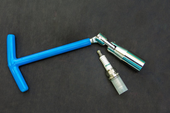 blue hinged key for spark plugs of an internal combustion engine needed at the service station and new sparking plug