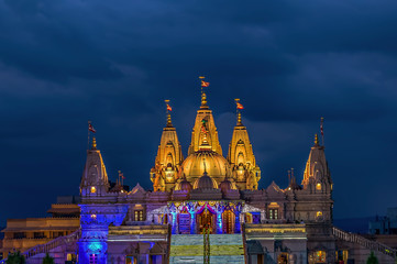 Lighted image of Shree Swaminarayan temple with monsoon clouds background, Ambe Gaon, Pune .