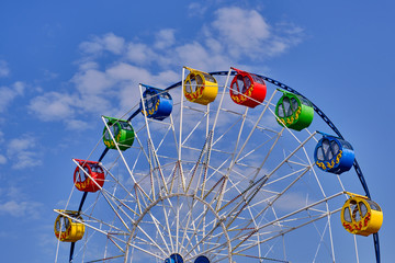 Part of a ferris wheel with round cabins decorated with ornaments