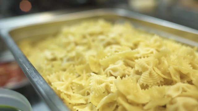 Close up of yellow boiled farfalle Italian pasta in tray