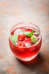 Raspberry and mint cocktail in glass on the rustic background. Selective focus. Shallow depth of field.