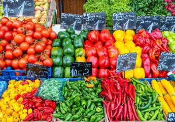 Different kind of peppers and some tomatoes for sale at a market