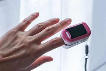 Hand with a portable pulse oximeter on the finger
