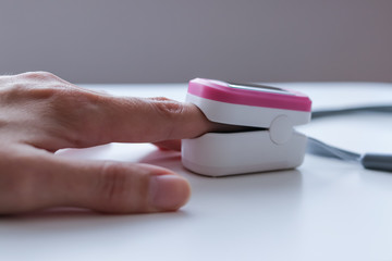 Hand with a portable pulse oximeter on the finger