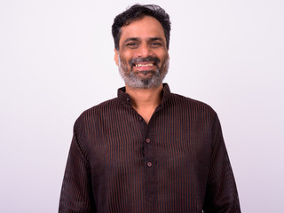 Portrait of happy mature handsome bearded Indian businessman