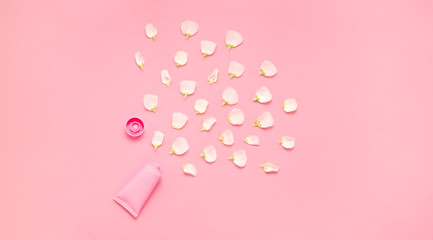 Delicate skin care cosmetic feminine flatlay. Top view Creative composition of face cream ,bottles and jars with cosmetic and flowers leaves on abstract background