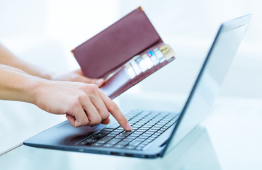 Online banking, travel booking, shopping and business. Male person's hands holding an open wallet with many  bank credit and debit cards while typing on a laptop computer keyboard at home.