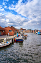 Fototapeta na wymiar Fishing boats in the port of Wismar with a seagull in the sky.