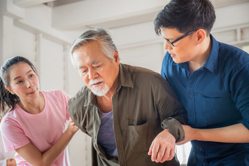 Son and daughter help support a senior father have a backache, Back pain in elderly adults, Asian...