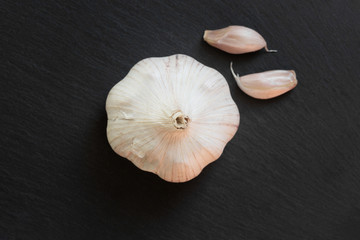 Garlic on a textured dark stone background. Superfood concept