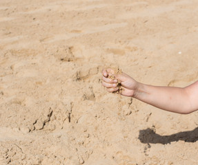 Sand falling from a woman's hand II